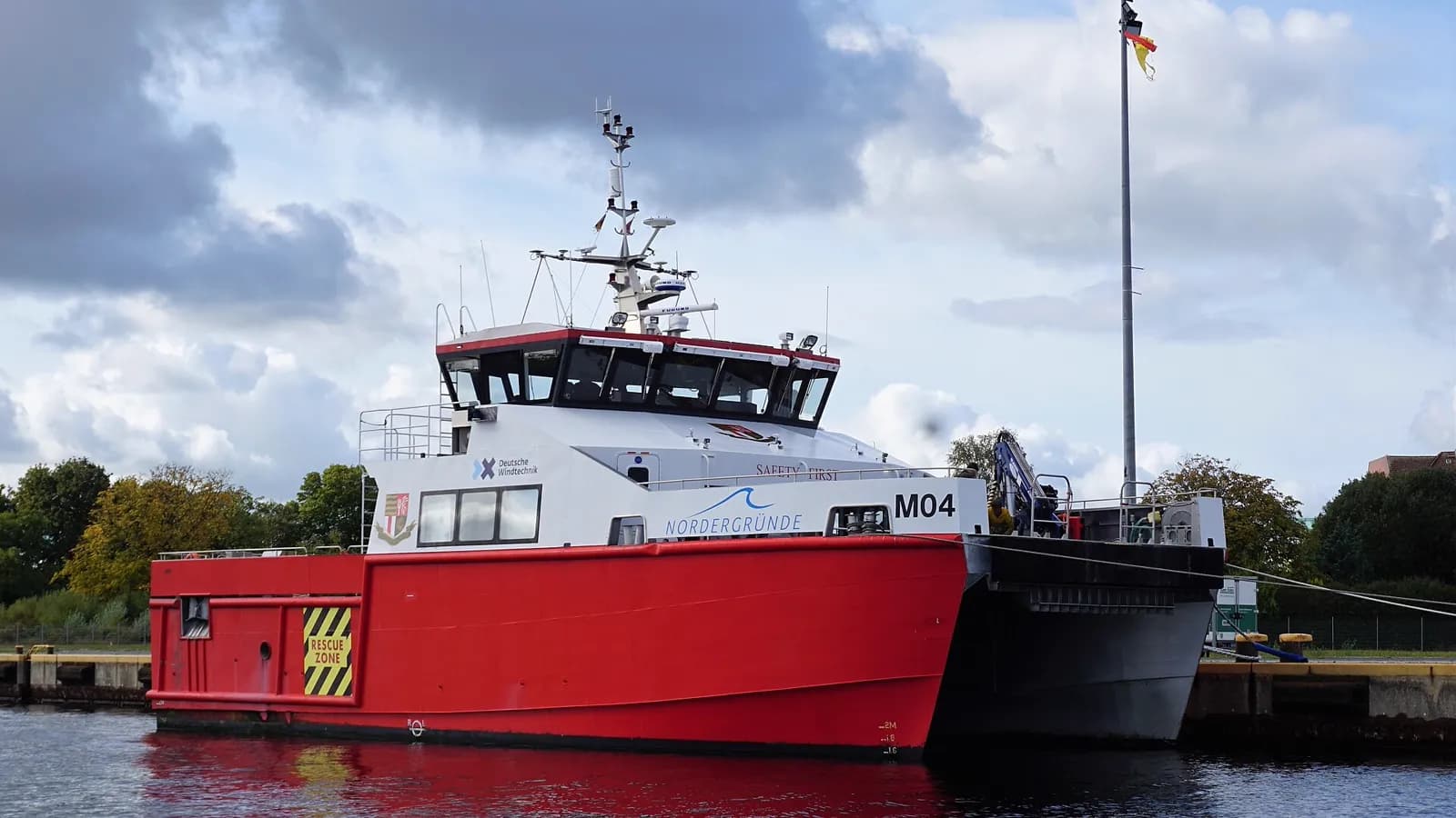 A crew transfer vessel alongside a quay, bow ramp raised